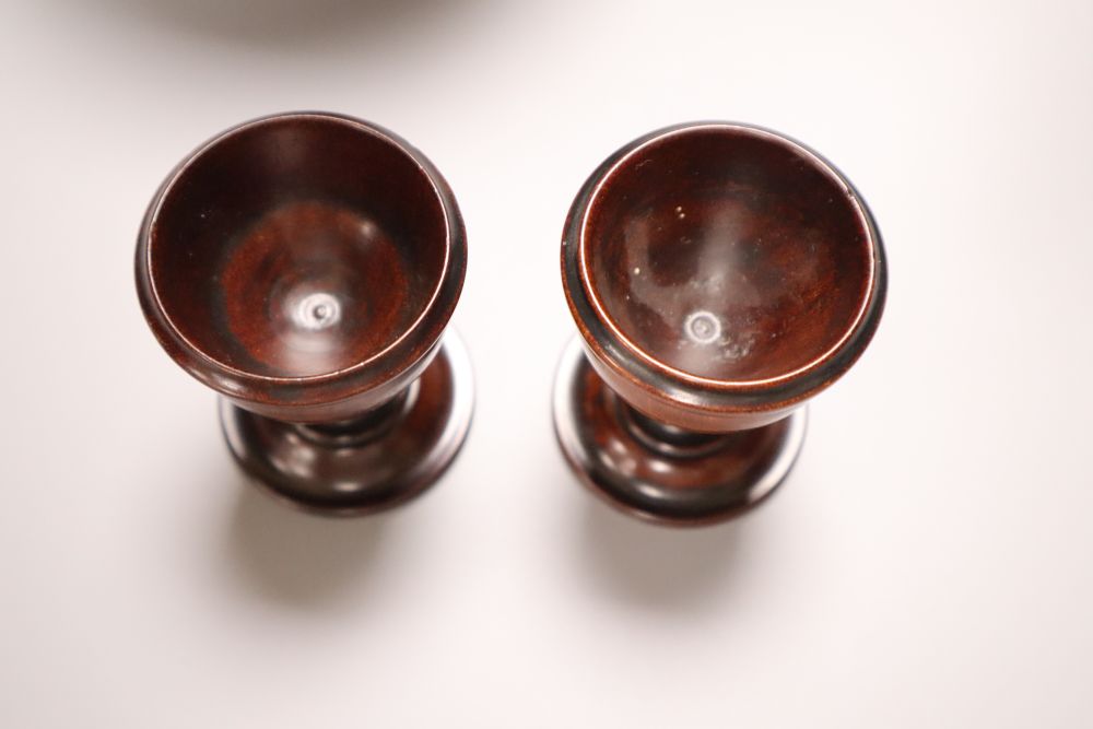 A 19th century turned amboyna urn, 11cm and two late Georgian turned mahogany egg cups, 6.5cm